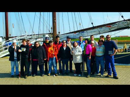 Gruppenfoto vom Segeltörn 29.04.-02.05.2014 im Hintergrund sieht man das Segelschiff Luciana bei strahlenden Sonnenschein auf der Insel Norderney